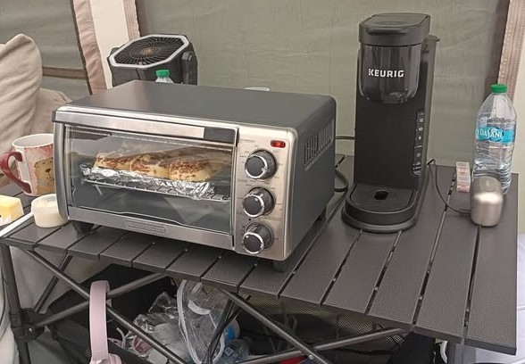 Camp kitchen with toaster oven, coffee maker, water, and folding table